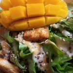 Caesar salad with a garnish of mango and sesame seeds